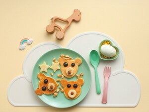 צלחת ירוקה ועליה פנקייקים בצורת דובונים לארוחת ערב