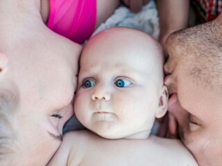 תינוק שוכב במרכז בין שני הוריו