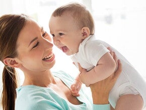 אמא מרימה את תינוקה ושניהם צוחקים