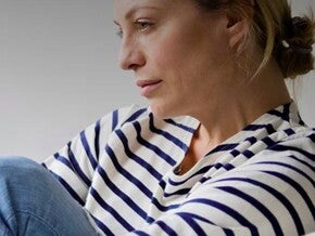 אישה אחרי לידה מביטה לפנים בעצבות