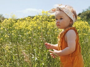 פעוטה על רקע פריחה אביבית