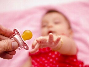 אמא מושיטה לביתה מוצץ