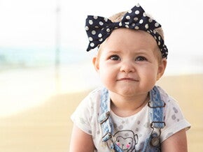 פעוטה זוחלת עם סרט על ראשה