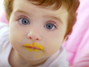 תינוק שפיו מלוכלך אחרי אכילת אוכל מחיתי כתום