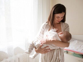 אם מחזיקה את תינוקה על הידיים