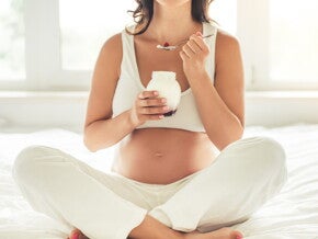 אישה בתחילת הריון אוכלת יוגורט