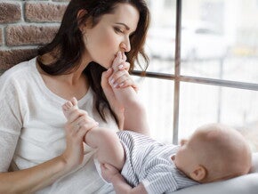 אם מנשקת את כפות רגליו של תינוקה