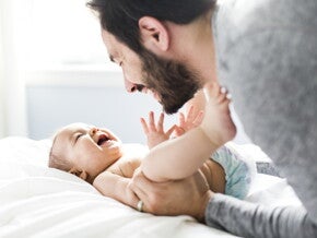 אבא מצמיד את רגליי התינוק לבטנו